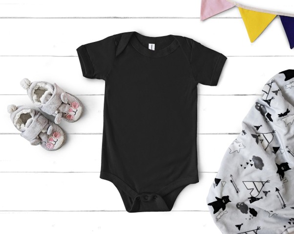 Organic cotton newborn bodysuit with baby shoes and blanket, representing sustainable infant clothing.