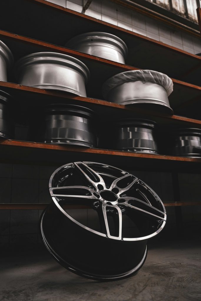 Finished alloy wheels stored on racks as export-ready automotive parts. The image shows completed alloy wheels organised in a controlled storage environment, highlighting finishing quality, inventory discipline, and the scalability required for supplying automotive parts to international markets.