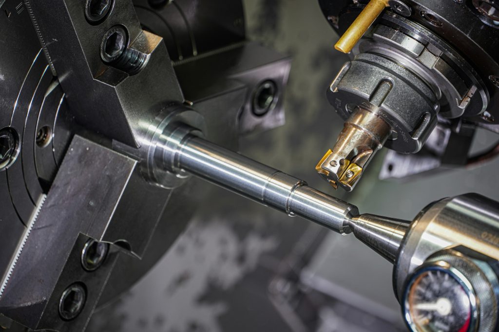 High-precision CNC machining supporting the production of automotive components. This image shows a CNC lathe machining a metal shaft with tight tolerances, illustrating the advanced manufacturing processes used to produce automotive components that meet global OEM standards for accuracy, durability, and repeatability.