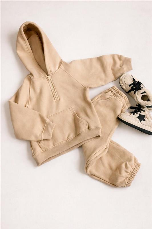 Minimal infant tracksuit styled on a clean flat lay of a neutral infant hoodie and jogger set, styled to pair with matching shoes as part of modern, minimalist kidswear assortments.