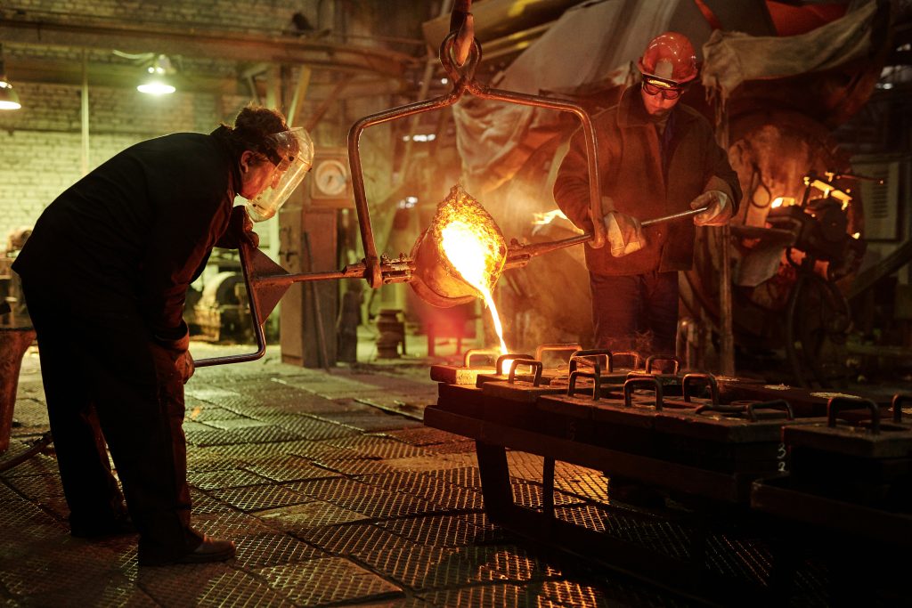 Casting manufacturers pouring molten metal into moulds during industrial foundry production. The image shows skilled workers at casting manufacturers pouring molten metal into prepared moulds inside an industrial foundry. This stage represents a critical step in the casting process, where controlled temperatures, precise handling, and safety protocols ensure dimensional accuracy, material integrity, and consistent quality across manufactured components.