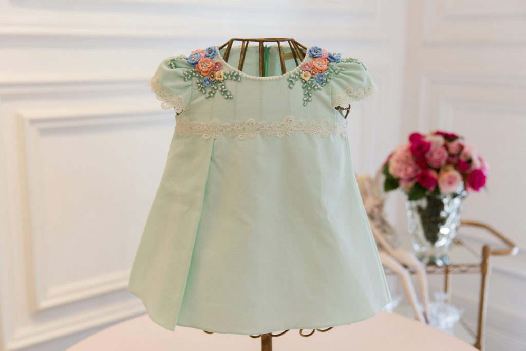 infant and children’s garment manufacturing with certified fabrics and safe trims. Baby dress produced through infant and children’s garment manufacturing processes that prioritise certified fabrics, compliant embellishments, and regulated children’s apparel production.