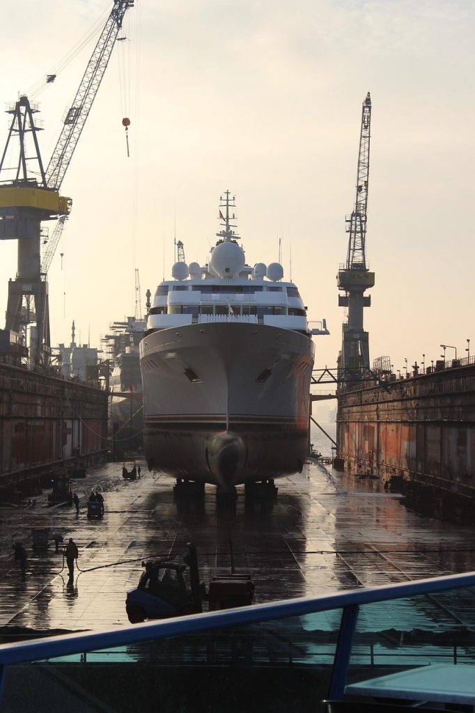 Large commercial vessel in dry dock undergoing shipyard inspection and maintenance. 